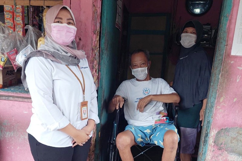 Representatives of theSocial Affairs Minisry delivery a wheelchair to a person with disability in Cibinong